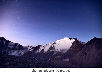 Snowy Mountains Under Blue Night Sky Full Of Stars In The Kazakhstan 