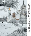 Snowy Orthodox Church with Golden Spire and Bare Winter Trees