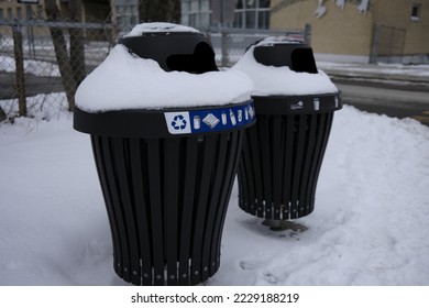 Snowy outdoor trash cans in a park in winter