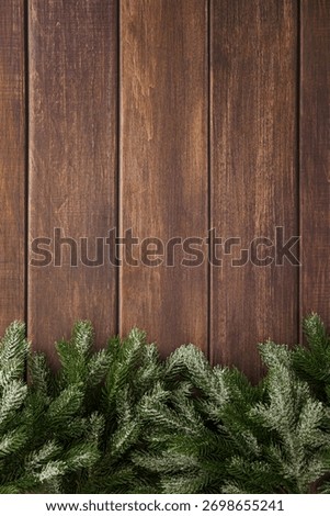 Snowy pine branches on rustic vertical wooden planks with winter holiday atmosphere