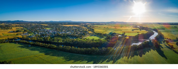 Snowy River Meanders Around Small Rural Town And Meadows At Sunset - Aerial Panoramic Landscape