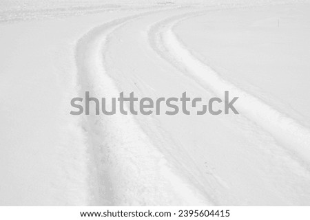 snowy road and car wheel marks in winter.