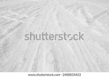 snowy road and car wheel marks in winter.