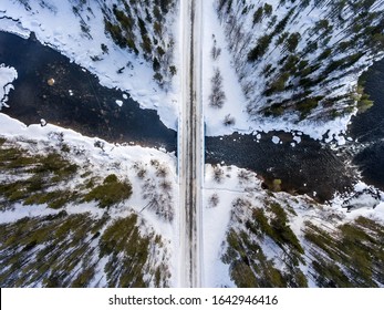 Snowy Road And Cold River In A Beautiful Winter Forest. Aerial Top Down View