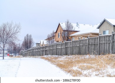 Snowy Road Side Along Wooden Fences Of Homes In A Beautiful Neighborhood