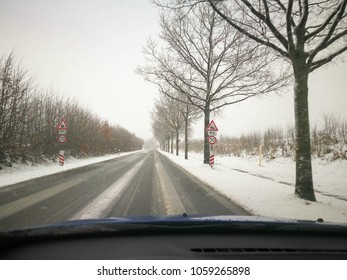 Snowy Road With Traffic Sign In Snowfall