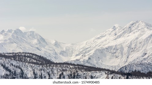 Snowy Rocky Winter Mountains With Woody Hill On Front
