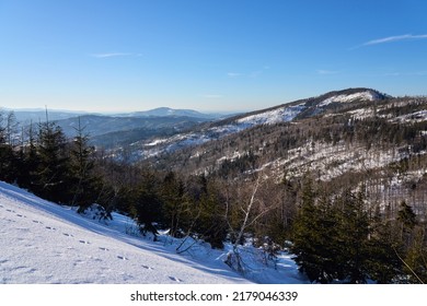 Der schneebedeckte Hang der schlesischen Beskid-Gebirge liegt auf der europäischen Bialy Krzyz in Polen, klarer blauer Himmel 2022 kalter sonniger Wintertag im Februar.