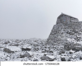 The Snowy Summit Of Ben Nevis With The Emergency Shelter Built On The Ruins Of An Observatory. 