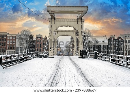 Snowy thiny bridge in Amsterdam the Netherlands in winter at sunset