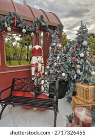 Snowy trees, a tall nutcracker, and candy canes create a magical outdoor Christmas train station.