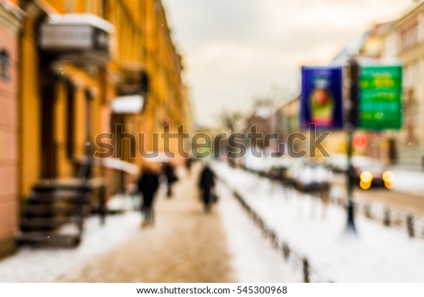 Snowy\
winter in the big city, the people go on street covered with snow\
and billboard on the roadside. Defocused\
image