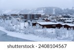 Snowy winter landscape of downtown Whitehorse, Yukon Territory, Canada, with buildings, frosted trees, snow covered streets and the not completely frozen Yukon River.