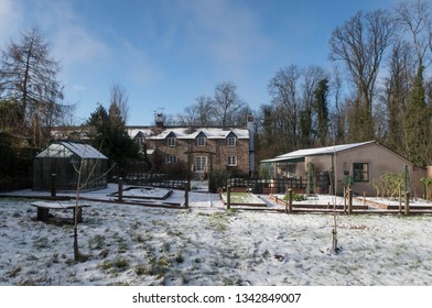 Snowy Winter Landscape Of A Traditional Devonian Stone Cottage And Garden In Rural Devon, England, UK