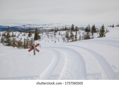 Snowy Winter In The Mountains On A Snow Mobile Road With A Hiking Trail Junction   