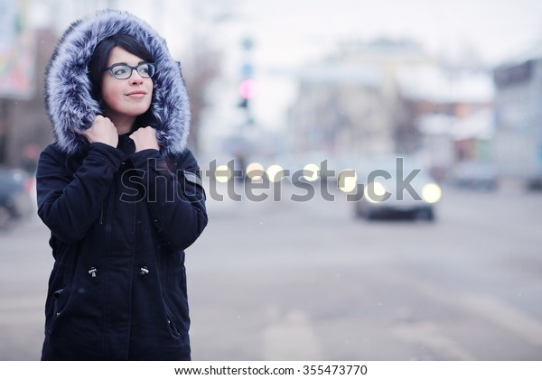 snowy\
winter portrait of a girl in the city on the\
road