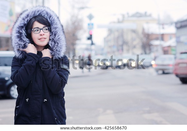 snowy\
winter portrait of a girl in the city on the\
road