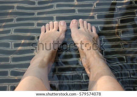 Soak your feet in the water by the swimming pool.