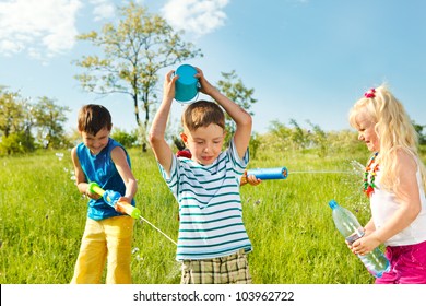 Soaked Happy Kids Playing With Water In The Meadow