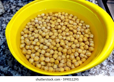 Soaking Chickpeas In Water In A Yellow Bowl