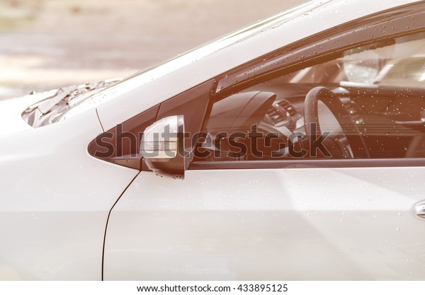 the soaking side mirror of white car, car\
mirror, side rear-view mirror on a modern\
car