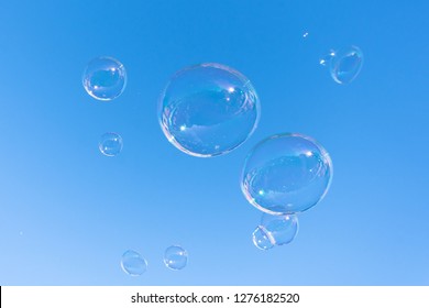 Soap Bubble Fly On Blue Sky Background