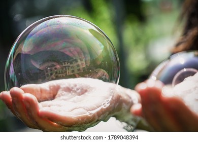Soap bubble on the palm of a hand, green blurred background     - Shutterstock ID 1789048394