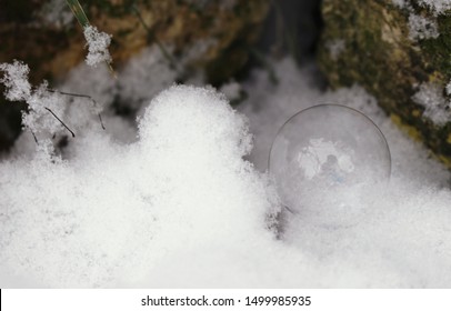 Soap bubble in the snow with reflection