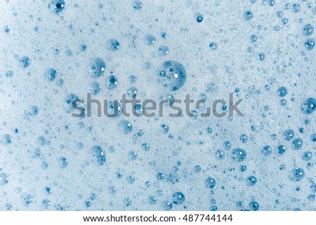 soap bubbles cleaning agent on the surface of the water