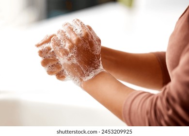 Soap, foam and person washing hands in home, kitchen or bathroom for protection from bacteria germs. Clean, skincare and woman closeup with self care for hygiene, safety and healthy routine in house - Powered by Shutterstock