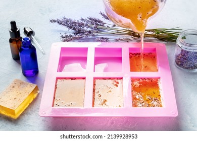 Soap Making At Home. Liquid Glycerin With The Additives Of Peels And Flower Buds Poured Into A Mould, With Essential Oils