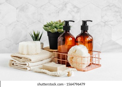 Soap and shampoo bottles and cotton towels with green plant on white table inside a bathroom background. - Shutterstock ID 1564796479