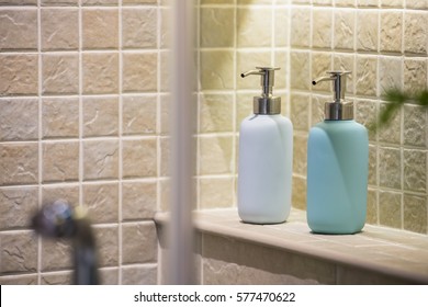 Soap And Shampoo Dispensers On A Shelf Inside A Shower Box / Bathroom