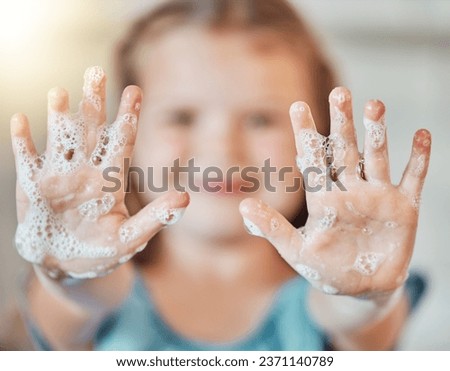Soap, washing hands and kid with foam for cleaning, hygiene and wellness in bathroom at home. Health, child development and palms of young girl with water for protection for germs, virus and bacteria