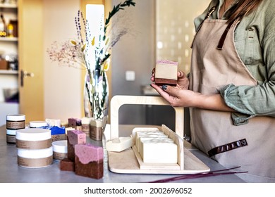 A soap-maker girl holds a piece of freshly brewed handmade soap in her hands.Cooking process.Home spa.Small business