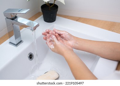 Soapy Hands Of A Child In The Washbasin Under A Stream Of Water In Foam