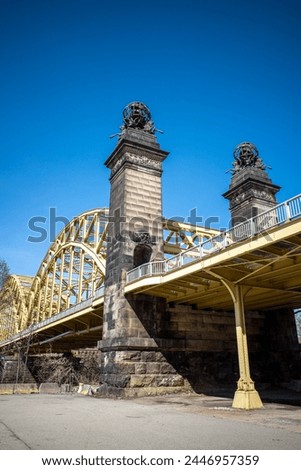 Soaring steel of the Sixteenth Street Bridge, Pittsburgh, Strip District, framed by clear blue sky.