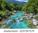 Soca Valley, Slovenia - Aerial view of the emerald alpine river Soca with rafting boats going down the river on a bright sunny summer day with green foliage. Whitewater rafting in Slovenia