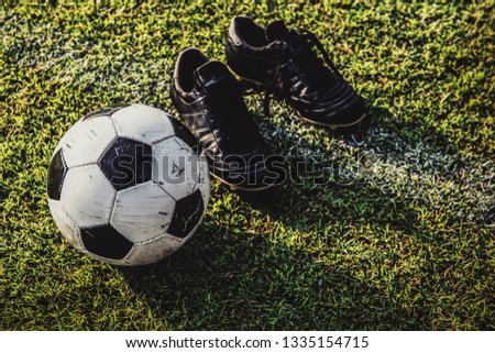soccer ball and boots on green grass 