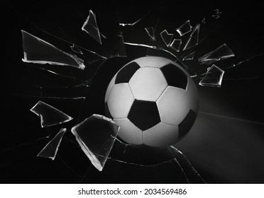 Soccer Ball Breaking Up Glass Against Black Background