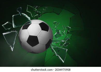 Soccer ball breaking up glass against green background