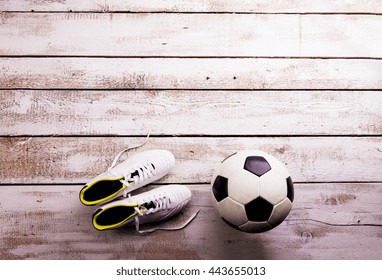 Soccer Ball, Cleats On White Wooden Floor, Studio Shot