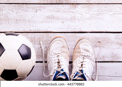 Soccer Ball, Cleats On White Wooden Floor, Studio Shot