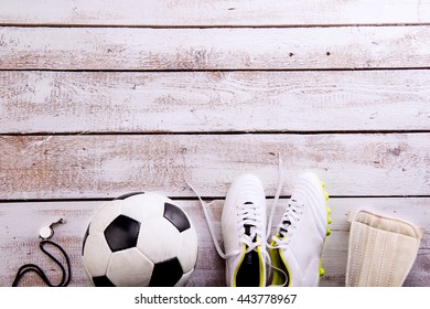 Soccer Ball, Cleats On White Wooden Floor, Studio Shot