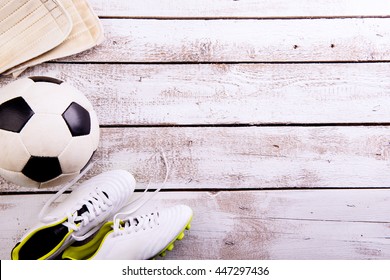 Soccer Ball, Cleats On White Wooden Floor, Studio Shot