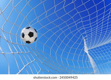  Soccer ball in soccer goal net in a big stadium isolated on blue sky. soccer net.