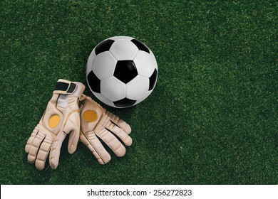 Soccer Ball And Goalkeeper Gloves On The Grass