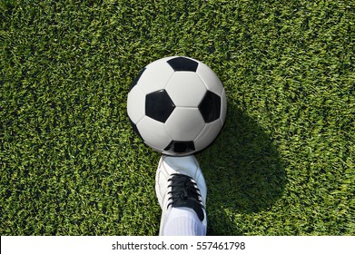 Soccer Ball With His Feet On The Football Field