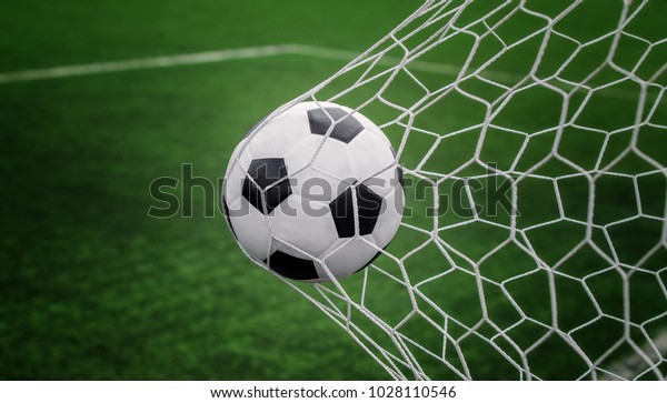 Soccer ball on goal with net and green\
background, this photo can use for football, sport, goal, score,\
shoot and target of business\
concept