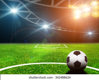 Soccer ball on green stadium, arena in night illuminated bright 